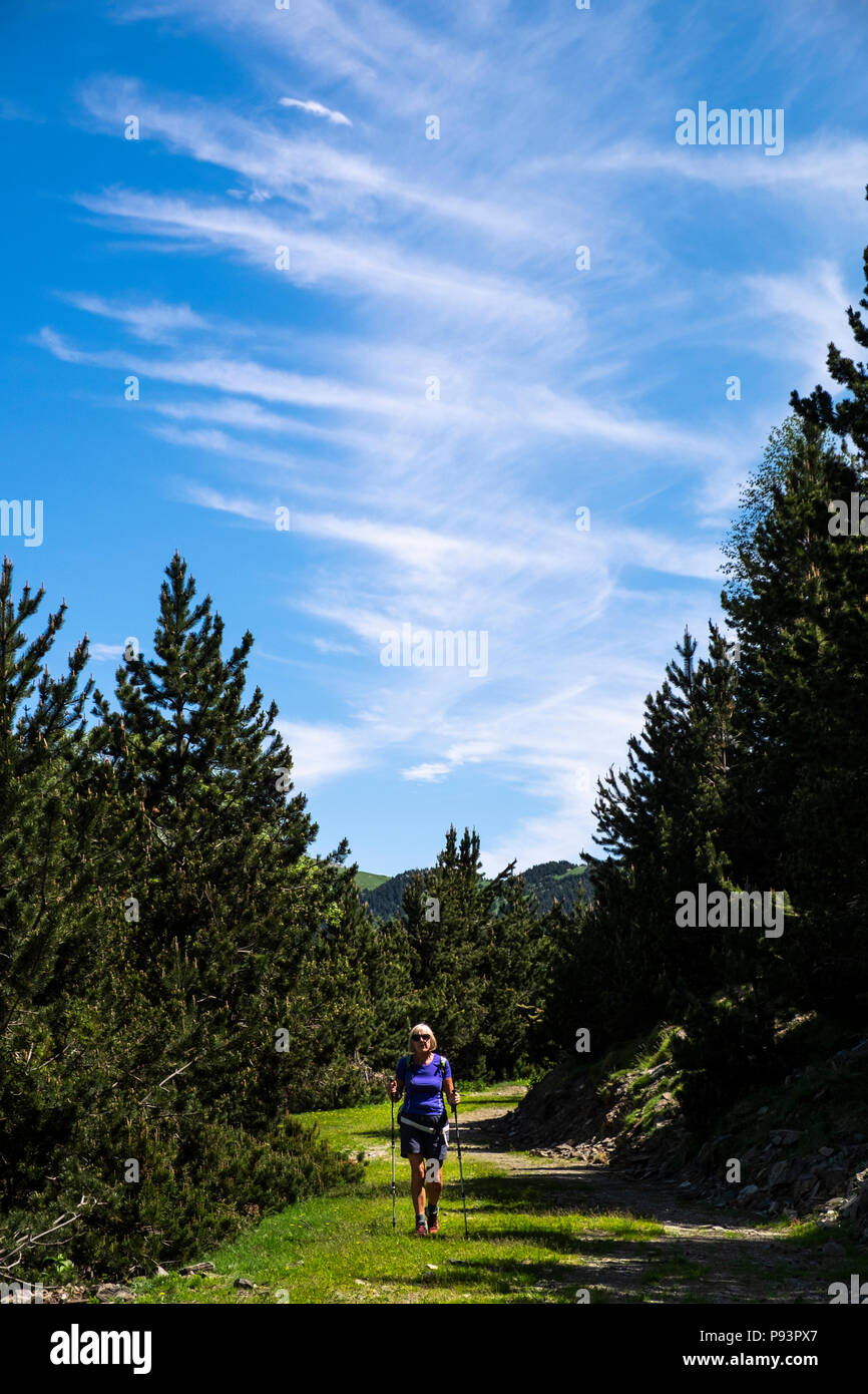 Woman hiker walking on the GR11 long distance path between Setcases and Mollo in the Catalonian Pyrenees, Spain Stock Photo