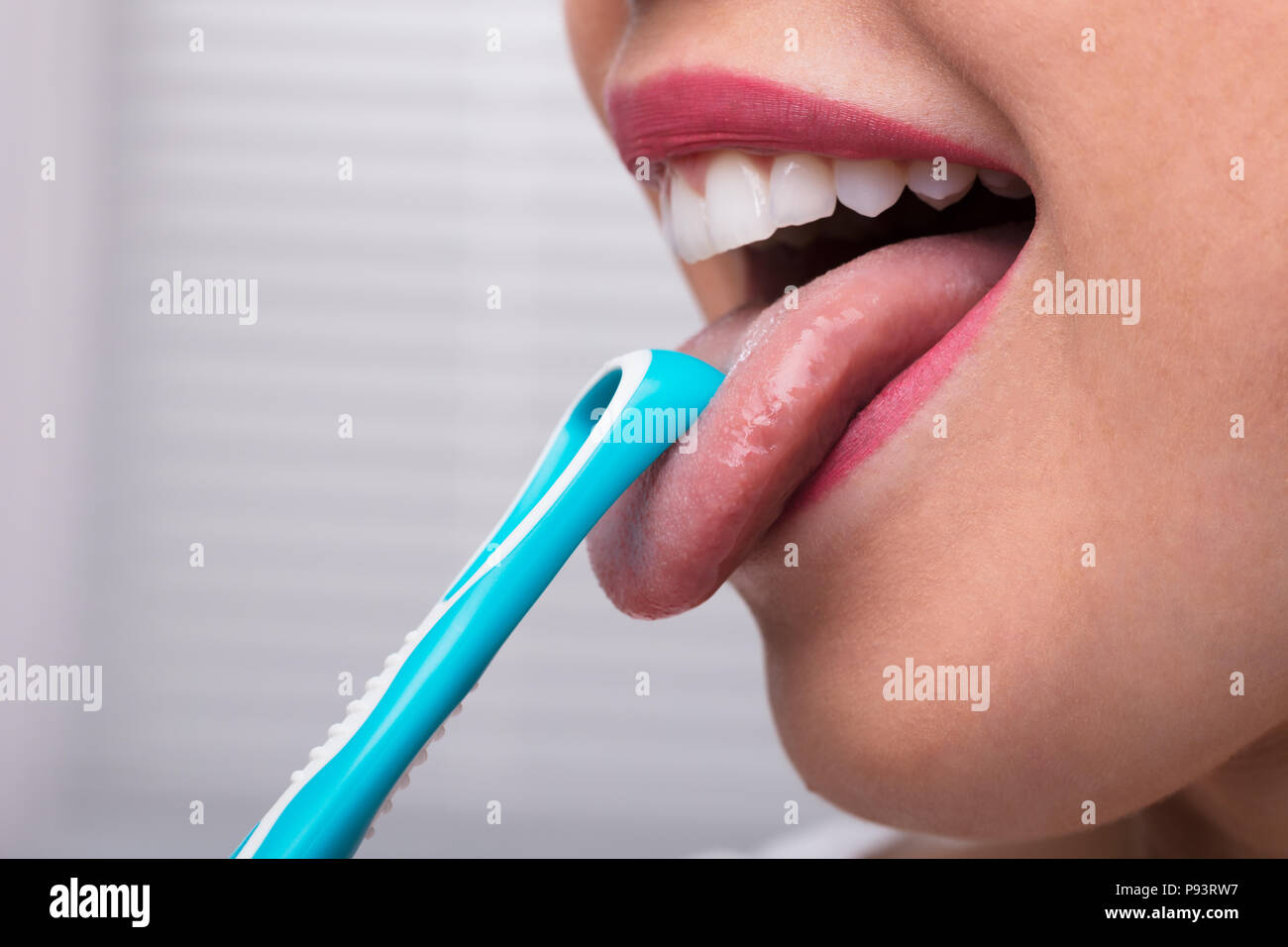 Close-up Of A Woman Cleaning Her Tongue With Cleaner Stock Photo