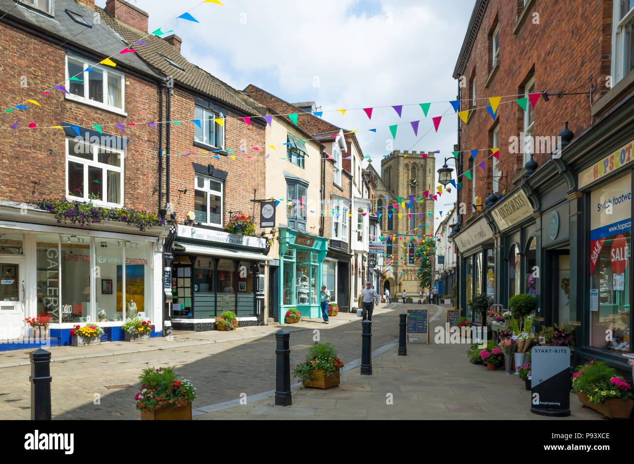A view down Kirkgate towards the  west face of Ripon Cathedral North, Yorkshire, UK, on a sunny summer day Stock Photo