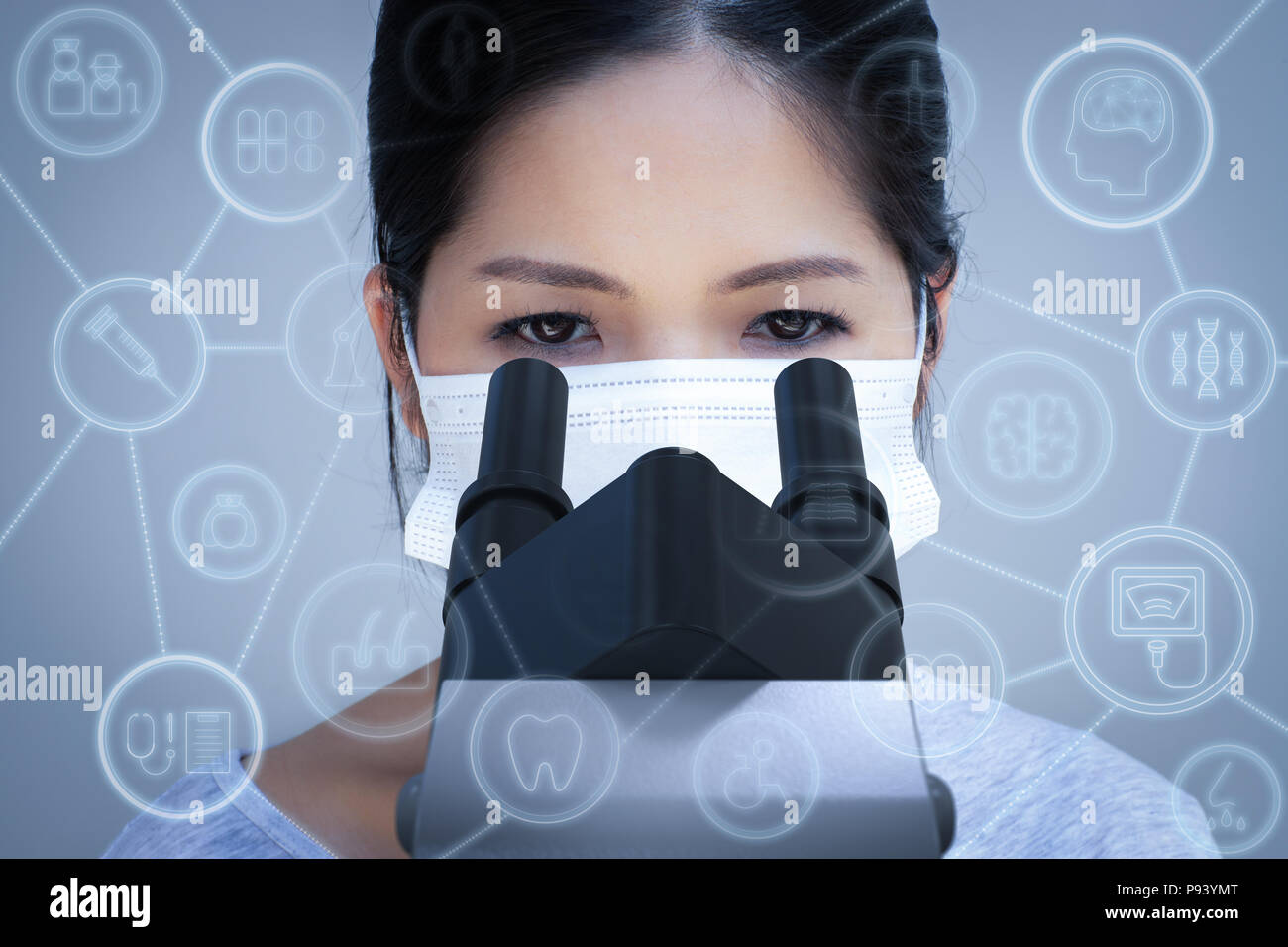 Asian scientist wearing face mask and looking at microscope Stock Photo