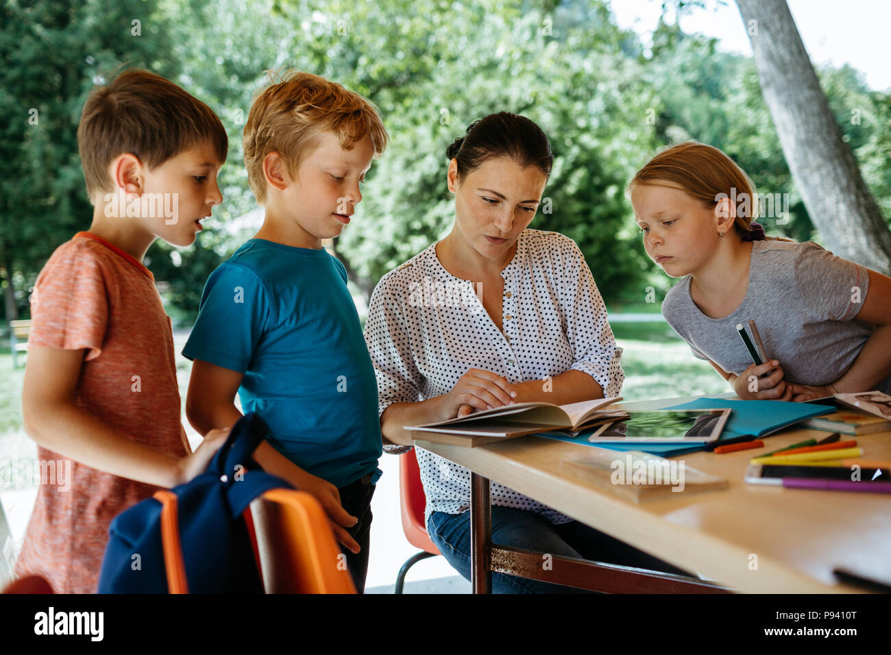 Teacher explaining a lesson to students hires stock photography and