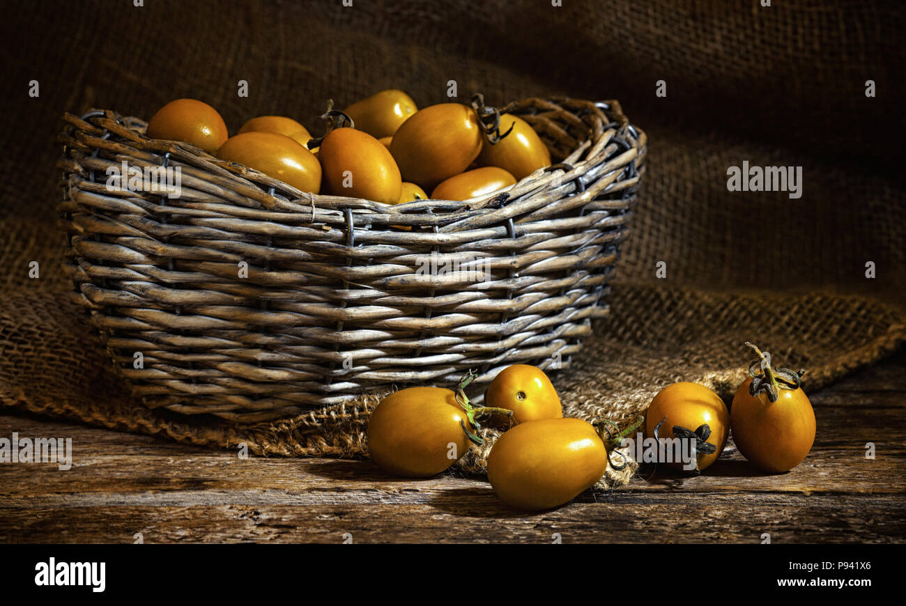 Varieties of yellow Heirloom cherry tomatoes called yellow pear and yellow datterino (or plum) cherry tomatoes. Stock Photo