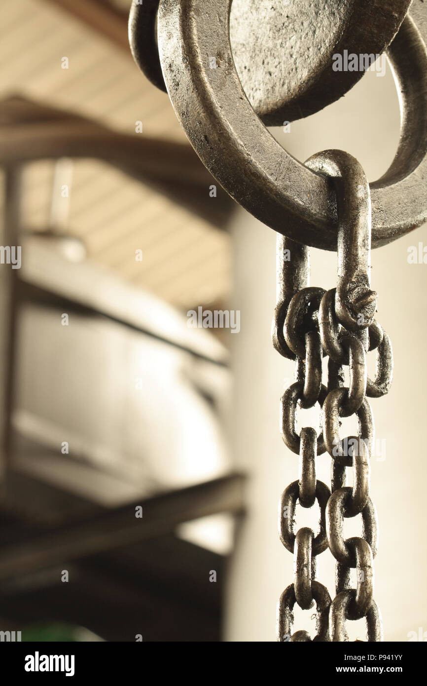 Closeup of steel chain fastening with metal ring hanging on crane hook Stock Photo
