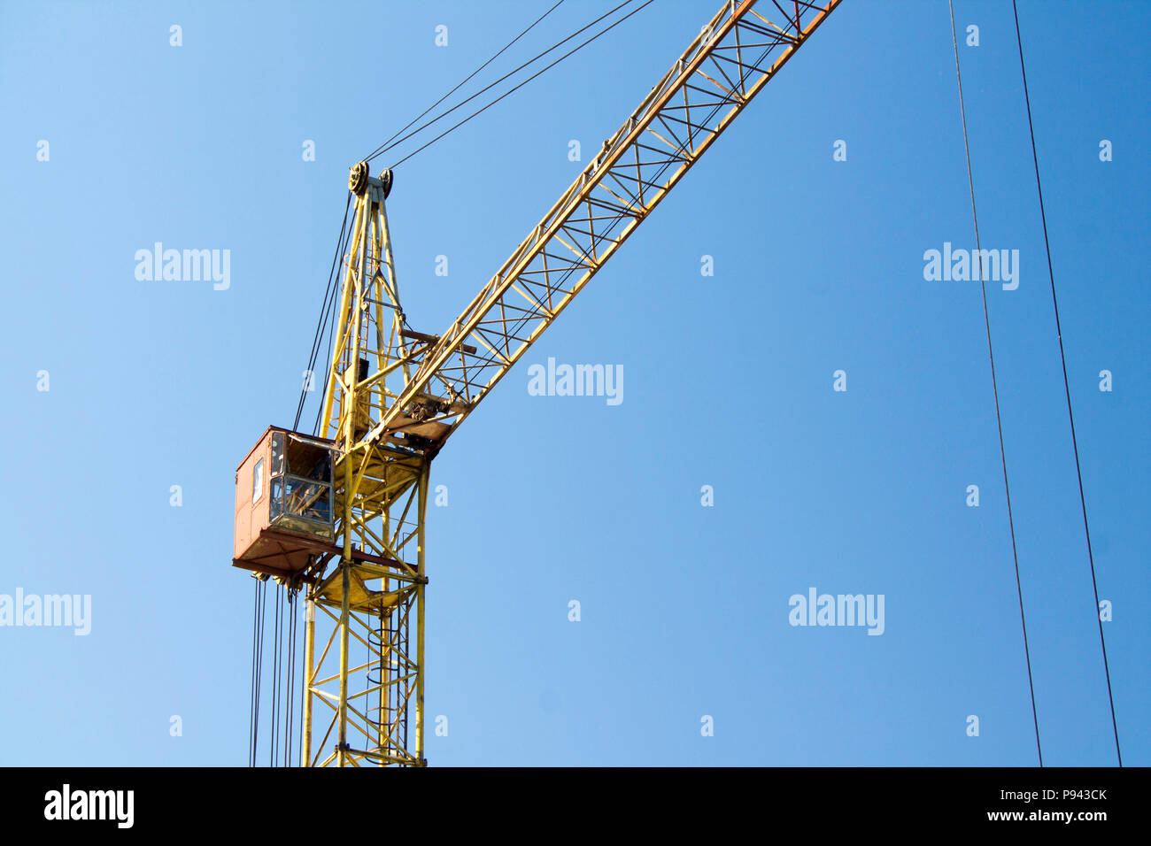 Photo of construction crane against a blue sky background. Stock Photo