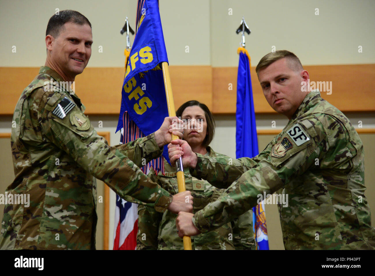 Maj. Michael Warren, right, accepts command of the 341st Security Forces Squadron from Col. Aaron Guill, 341st Security Forces Group commander, during an assumption of command ceremony July 6, 2018, at Malmstrom AFB, Mont. Senior Master Sgt. Jaime Mathews, 341st SFS first sergeant, looks on. (U.S. Air Force photo by Airman 1st Class Tristan Truesdell) Stock Photo