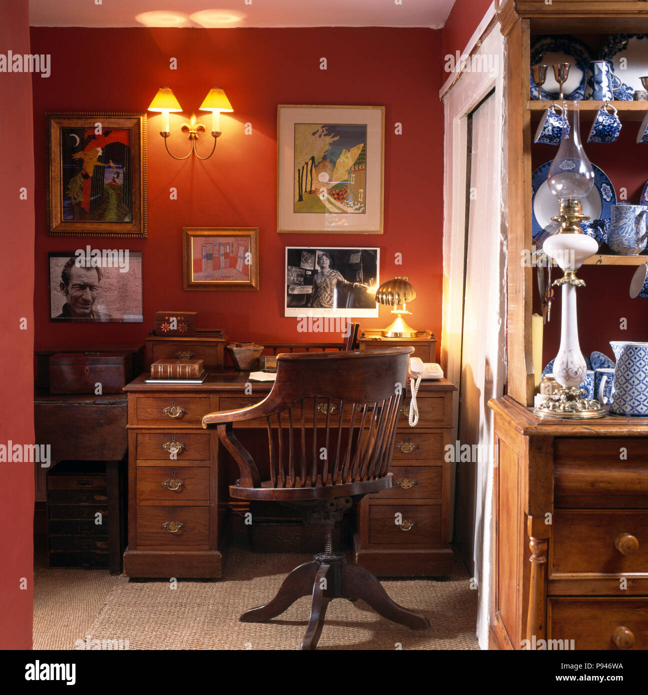 Antique desk and old office swivel chair in corner with wall lighting. Stock Photo