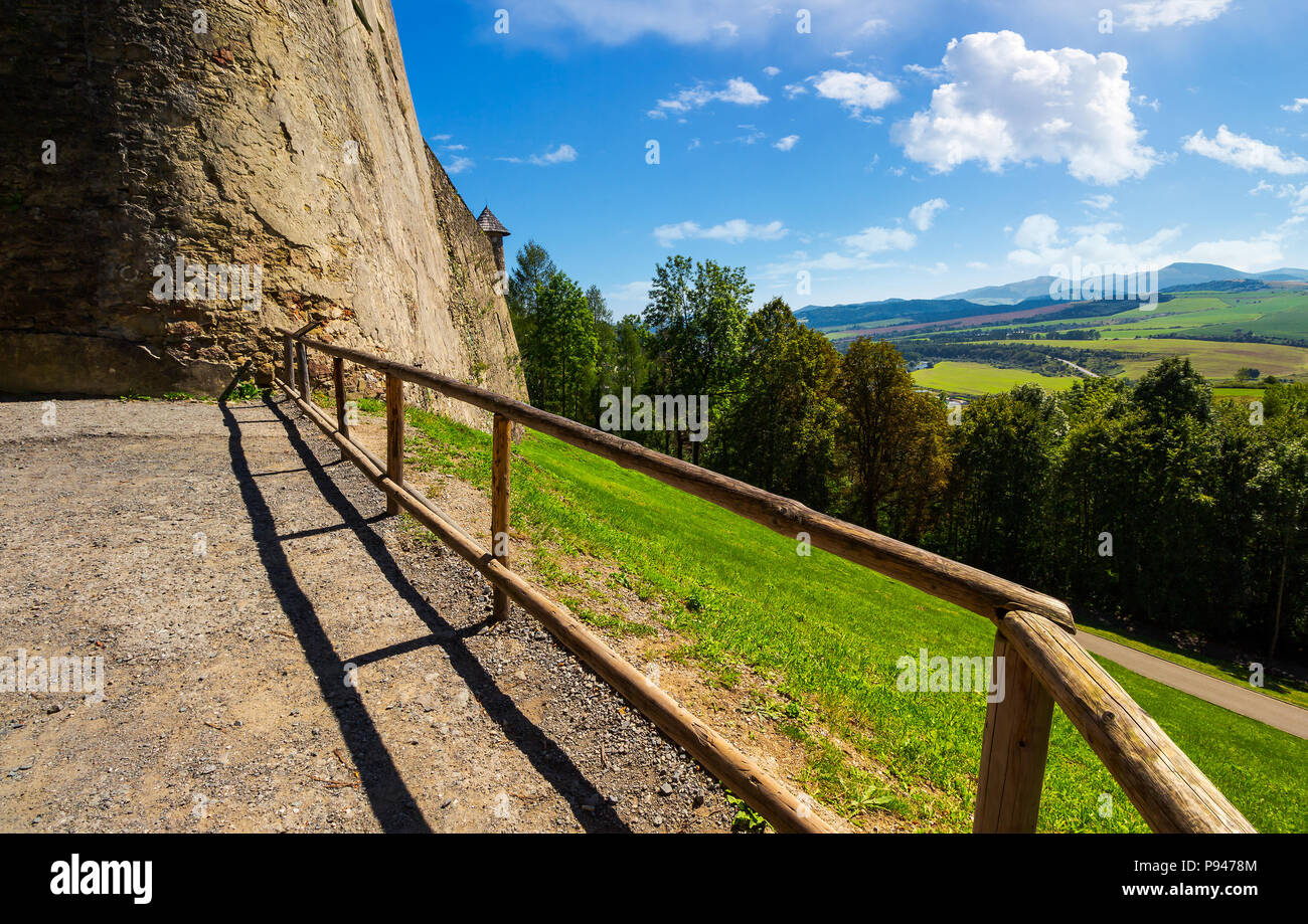 castle wall and railing on a hill. view in to the beautiful mountainous landscape Stock Photo