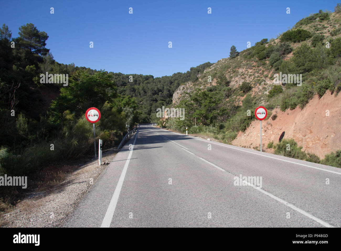 Empty road through the Parque Naturel sierra Magina, Jaen province, Spain with no overtaking signs Stock Photo