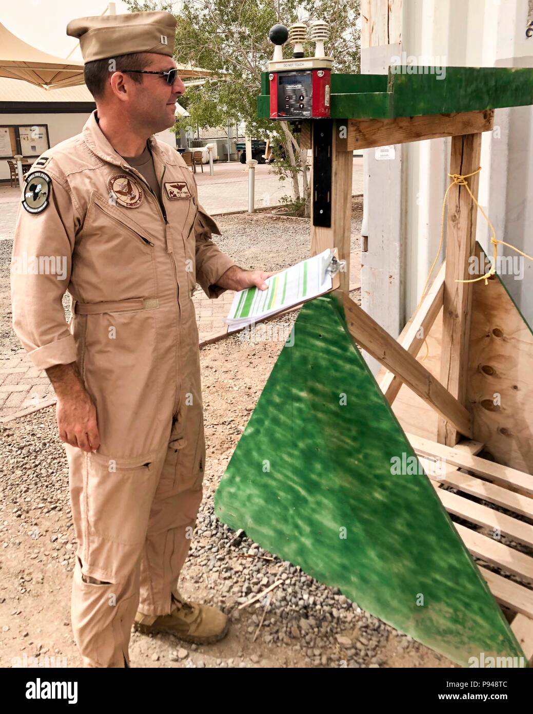 CAMP LEMONNIER, Djibouti – Camp Lemonnier (CLDJ) Safety Officer, Navy Lt. Rich King, inspects the Wet Bulb Globe Temperature (WBGT) device, which is used to measure environmental conditions during physical exercise, June 6, 2018. CLDJ is scheduled to install a second WBGT unit near the turf field on base. Stock Photo