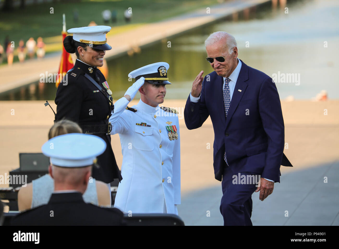 Former Vice President of the United States, Joe Biden, salutes the hosting element as he prepares to take his seat as the guest of honor during a Tuesday Sunset Parade at the Lincoln Memorial, Washington D.C., July 10, 2018.  Biden was the guest of honor and the hosting official was the Staff Judge Advocate to the Commandant of the Marine Corps, Maj. Gen. John R. Ewers Jr. (Official Marine Corps photo by Cpl. Damon Mclean/Released) Stock Photo