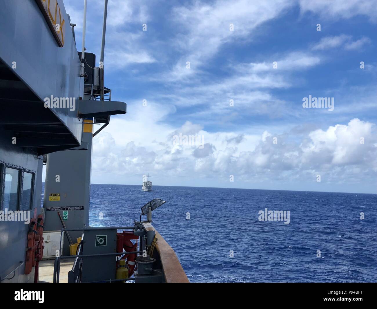 The decomissioned Navy landing ship-tank Ex-Racine, travels behind the Military Sealift Command fleet ocean tug on tow lines as it is delivered to RIMPAC 2018's designated target area in preparation for sinking exercises (SINKEX).  Sioux's tow support is part of MSC's ongoing participation in this year's RIMPAC exercise in Hawaii.     Twenty-five nations, 46 surface ships, five submarines, 18 national land forces, more than 200 aircraft, and 25,000 personnel will participate in the biennial RIMPAC exercise scheduled June 27 to Aug. 2.    This year's exercise includes forces from Australia, Bru Stock Photo