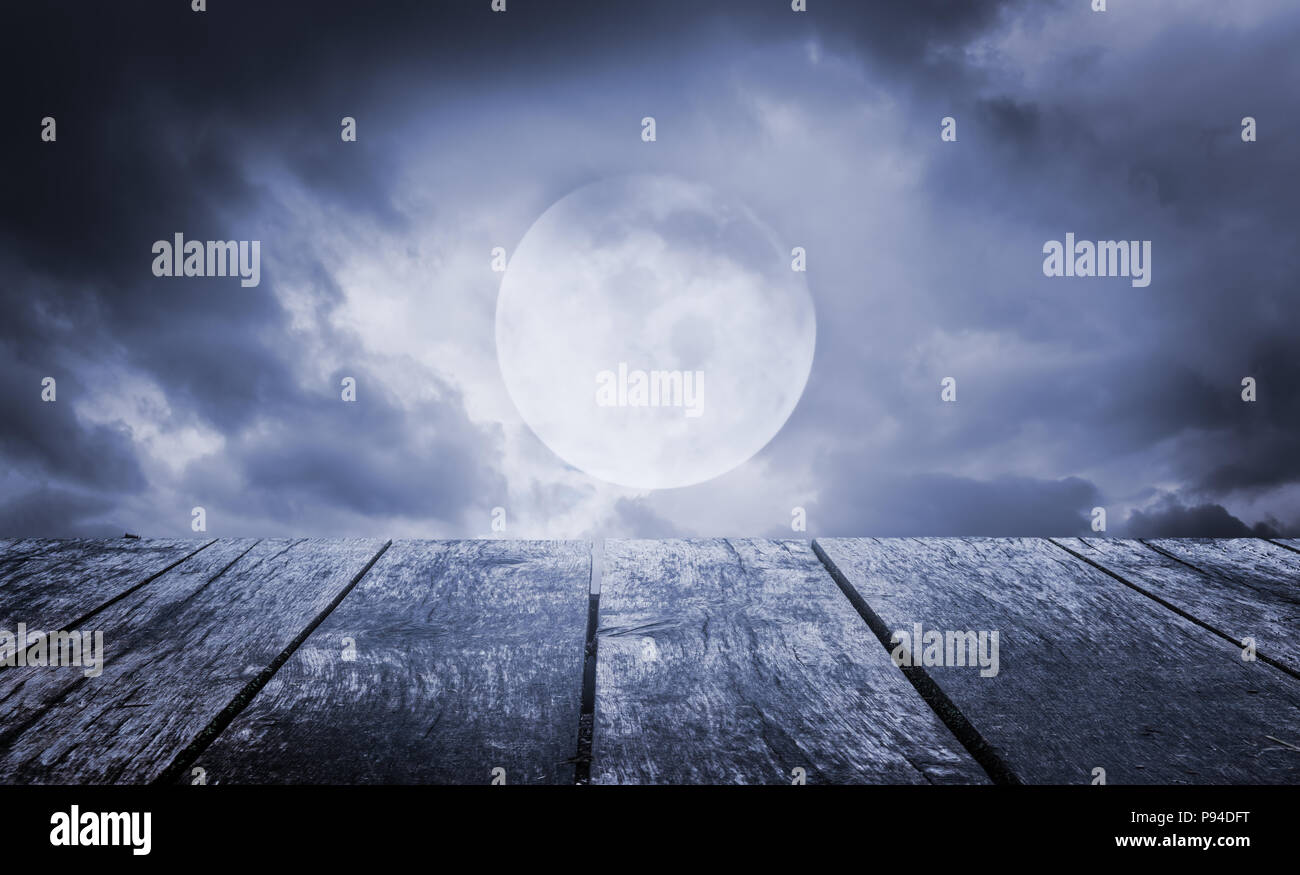 Halloween background. Spooky sky with full moon and wooden table Stock Photo