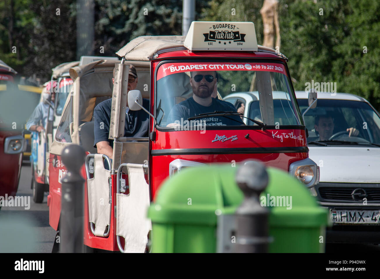 Tourists explore the European city of Budapest, Hungary while riding in tuk tuks. Stock Photo