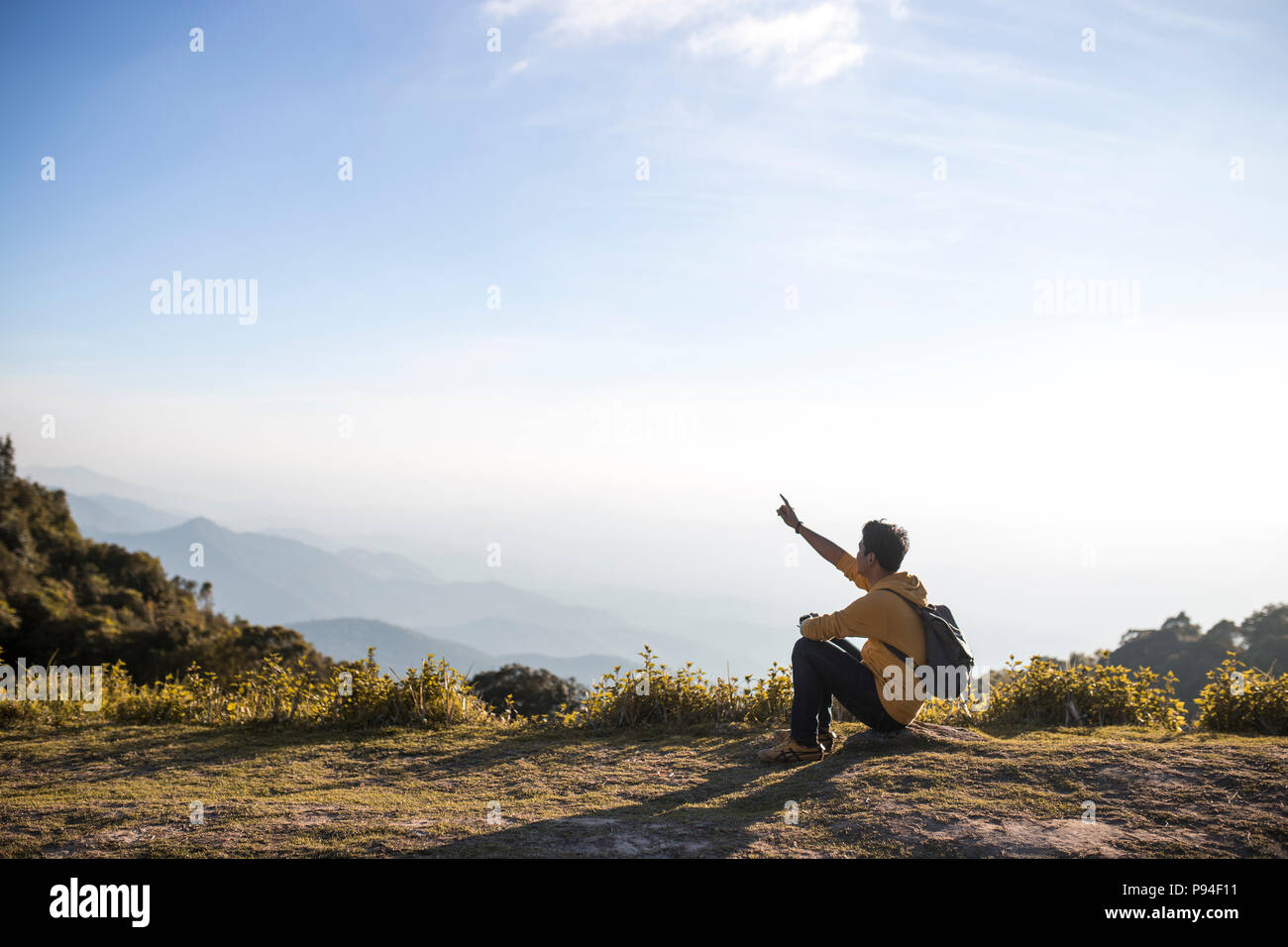 A man sitting on the top of mountain Stock Photo - Alamy