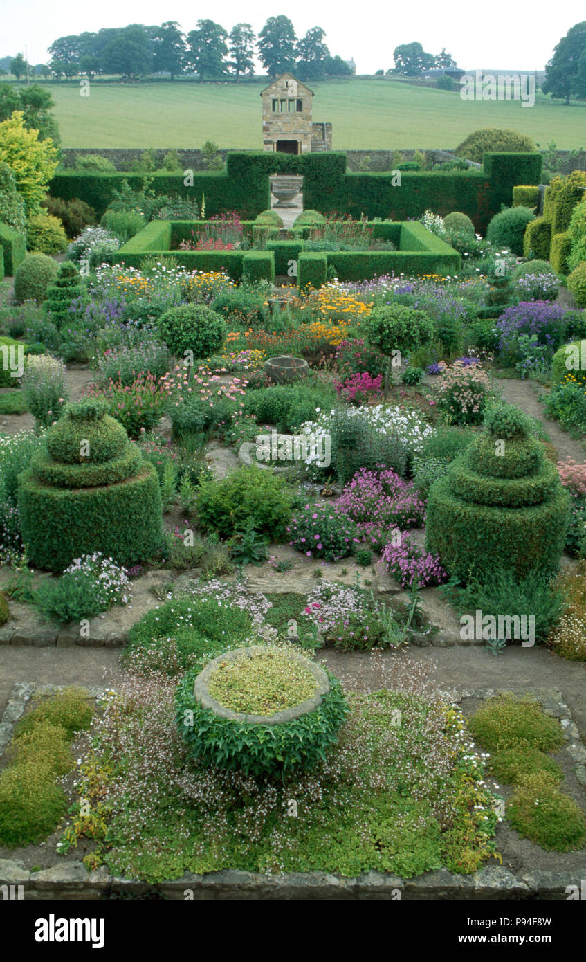 Birds-eye view of formally clipped shrubs and hedges in a large country garden with brightly flowering perennials Stock Photo