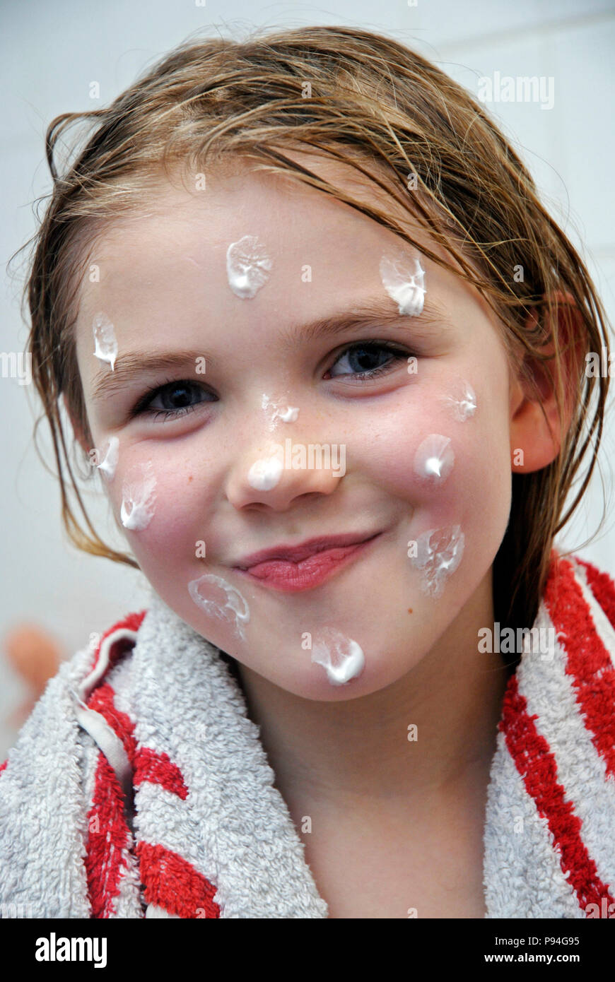 Emma mit Hautcreme-Tupfern im Gesicht Stock Photo