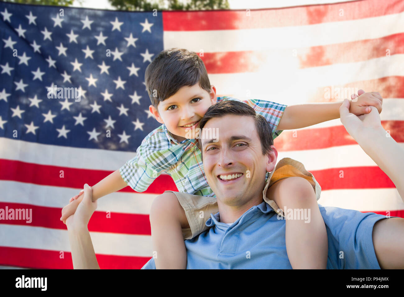 Father with Son Piggy Back Riding In Front of American Flag Stock Photo