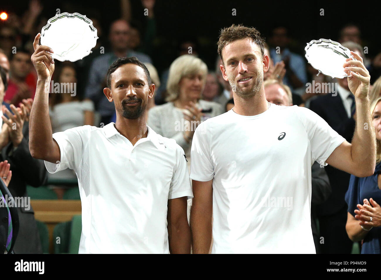 Raven Klaasen (left) and Michael Venus hold up the runners up trophy after the Gentlemen's doubles final on day twelve of the Wimbledon Championships at the All England Lawn Tennis and Croquet Club, Wimbledon. PRESS ASSOCIATION Photo. Picture date: Saturday July 14, 2018. See PA story TENNIS Wimbledon. Photo credit should read: Jonathan Brady/PA Wire. RESTRICTIONS: No commercial use without prior written consent of the AELTC. Still image use only - no moving images to emulate broadcast. No superimposing or removal of sponsor/ad logos. Stock Photo
