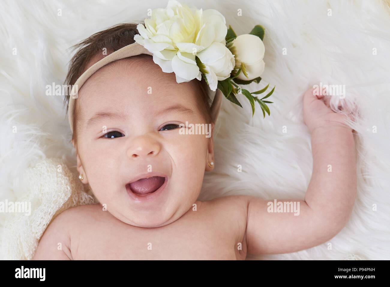 Portrait of smiling cute baby girl lay on soft white background Stock Photo
