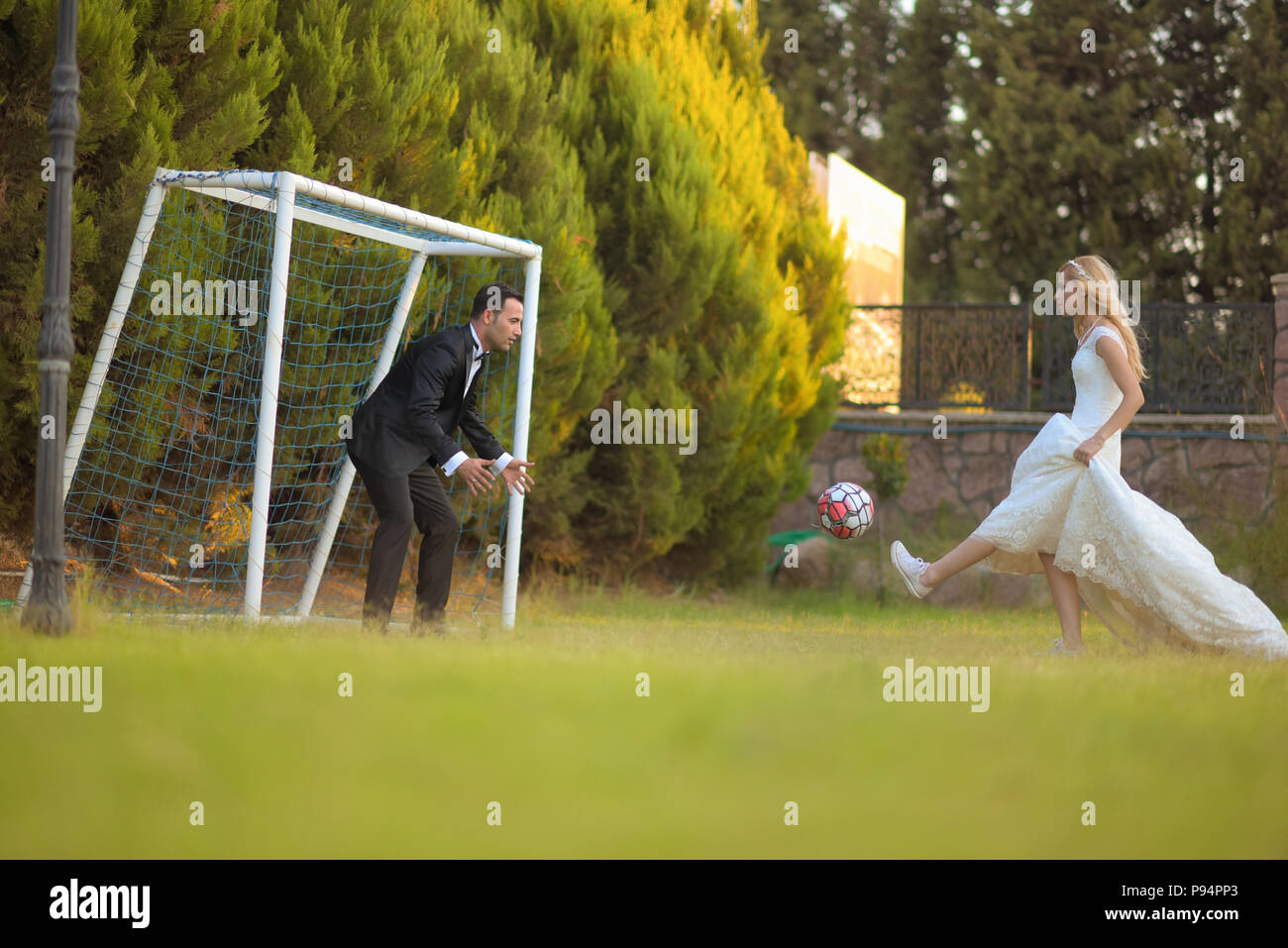 Wedding bride and groom playing football  soccer game bridegroom love marriage marrying couple Stock Photo