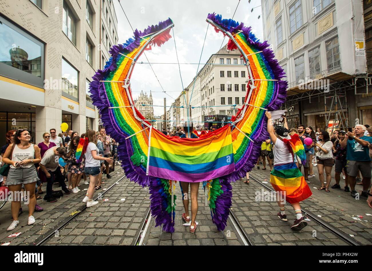 Munich, Bavaria, Germany. 14th July, 2018. A participant of the Christopher  Street Day parade in Munich, Germany shows off his large construction of  pride wings. Under the banner of "Bunt ist die