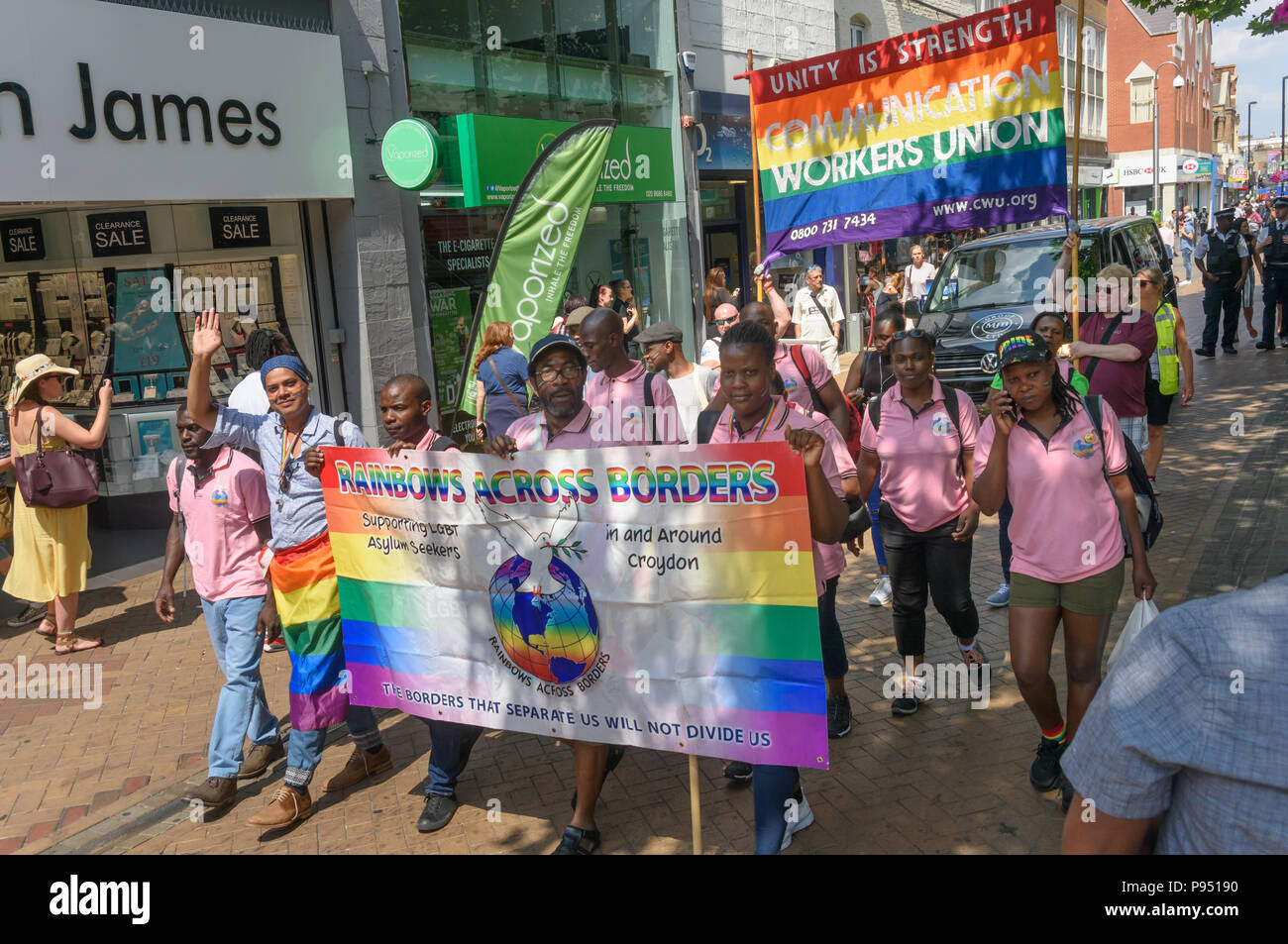 London, UK. 14th July 2018. Rainbows Across Borders, a group which supports LGBT asylum seekers and the Communication Workers Union at the read of the Croydon Pride procession. Several hundred people parade through the centre of Croydon on their way to the third Croydon Pridefest, sponsored by Croydon Council, in Wandle Park. Many were in colourful dress and there were banners, flags, placards, posters and unicorns. The free festival aims to promote LGBT+ equality and diversity in Croydon, and is London's second largest Pride festival. Following the disruption by anti-Trans activists at London Stock Photo