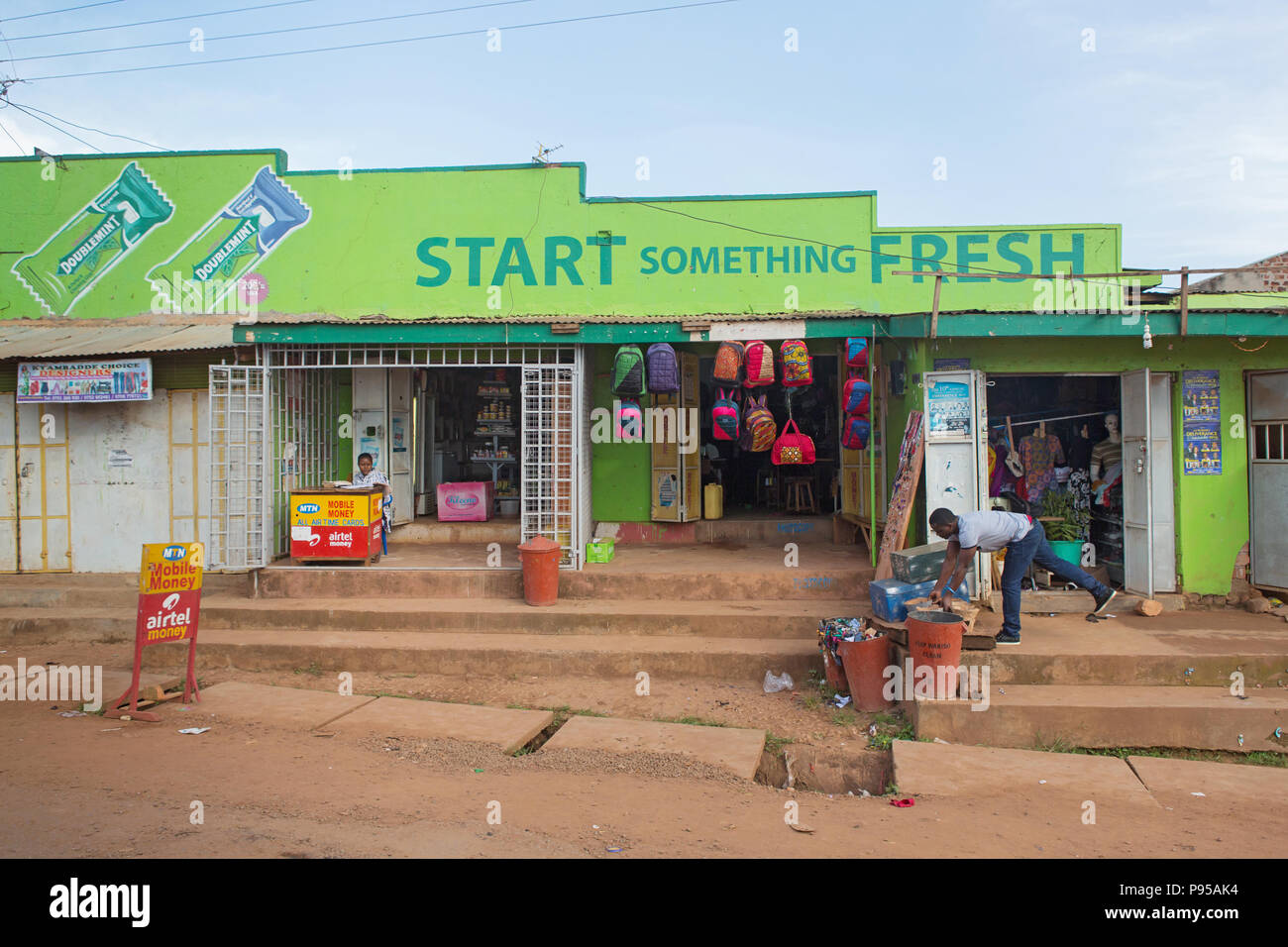 Wakiso Town, Uganda - Street scene. Store shops with bubble gum reclaimer Stock Photo