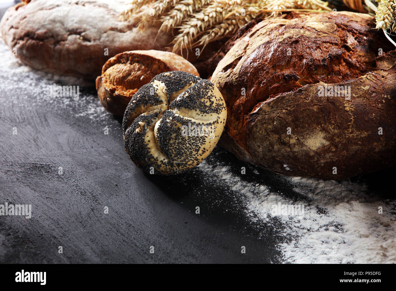 Different kinds of bread and bread rolls on board from above. Kitchen or bakery poster design