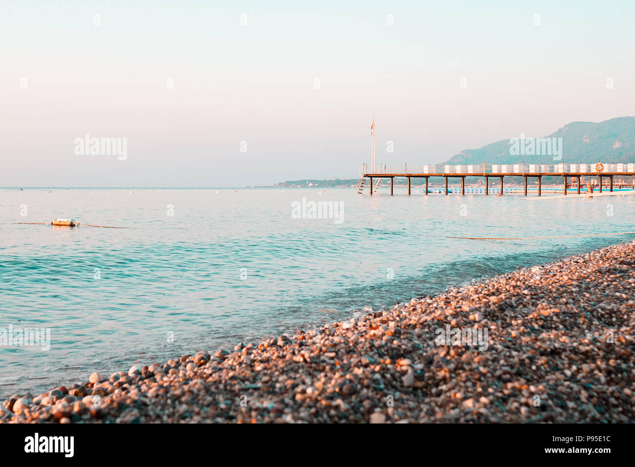 Early morning beach pier and sea against clear skyline Stock Photo