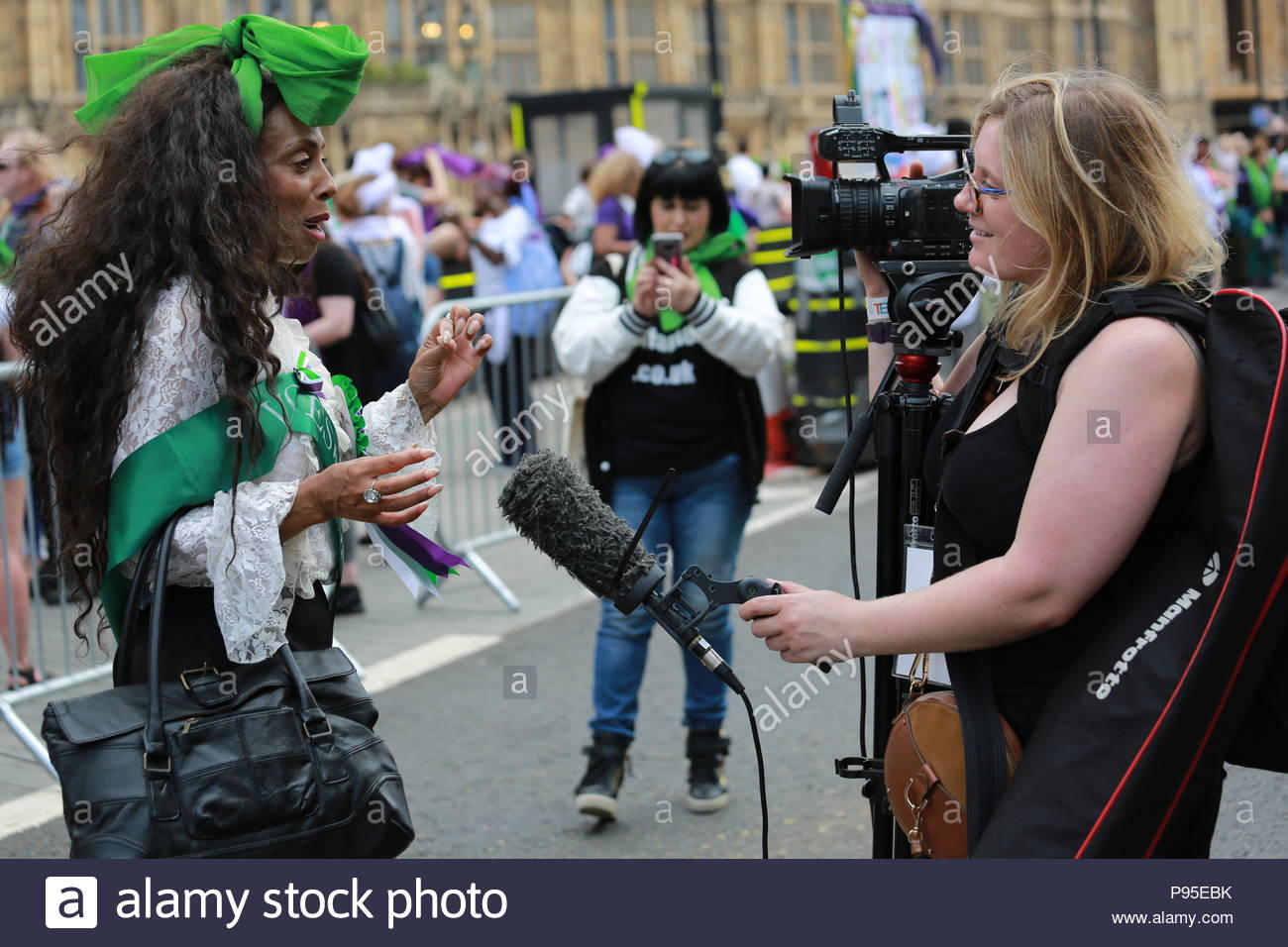 A woman is interviewed at the end of a march to Westminster in honour of suffragettes who won the vote in 1918. Stock Photo