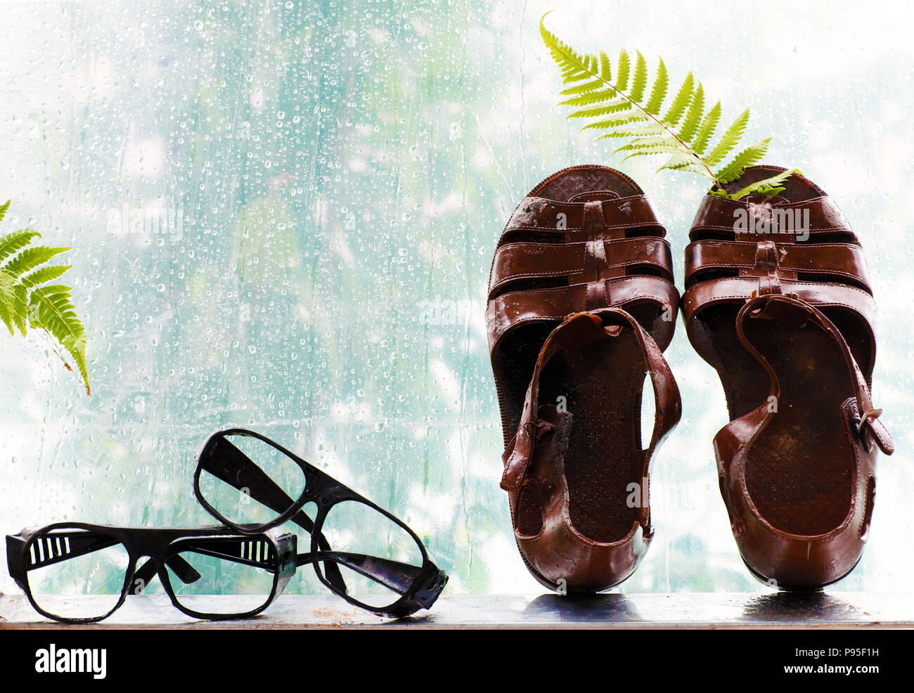 Couple of plastic sandals beside on window with rainy background rain drops in rainy day cyan color make beautiful and art scene Stock Photo Alamy