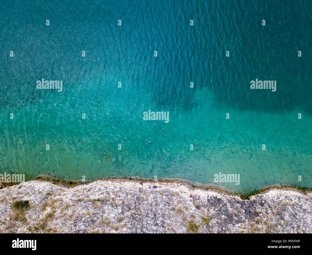 Aerial view of rocks on the sea. Overview of seabed seen from above, transparent water. Cliff on the sea Stock Photo