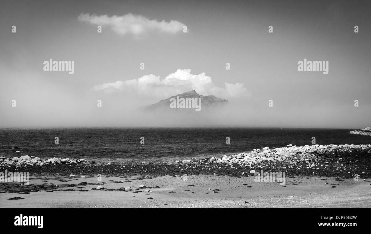Crest of a hill being revealed behind the cloud from a beach on the Isle of Skye Stock Photo