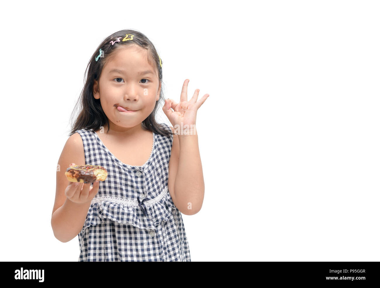 Happy cute girl is eating donut isolated on white background. Stock Photo