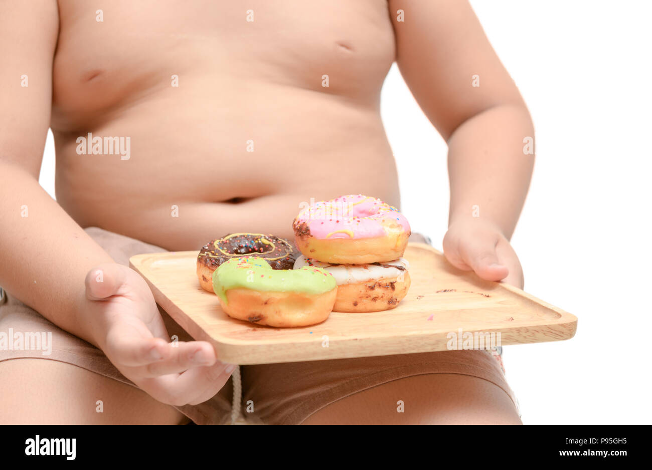 Obese fat boy is holding donut isolated on white background, junk food and dieting concept Stock Photo