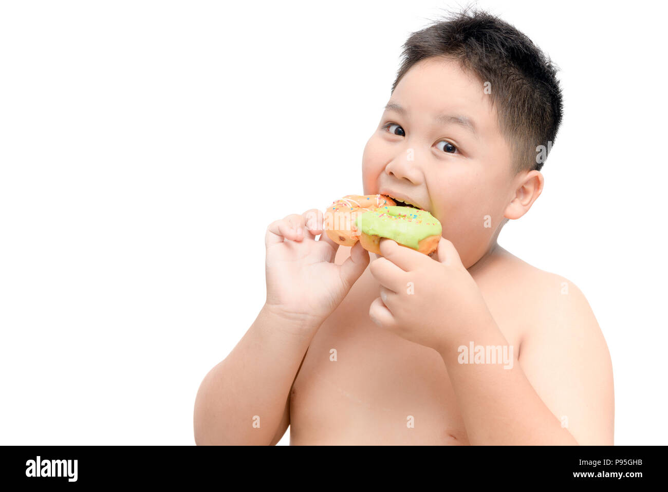 Obese fat boy is eating donut isolated on white background, junk food and dieting concept Stock Photo