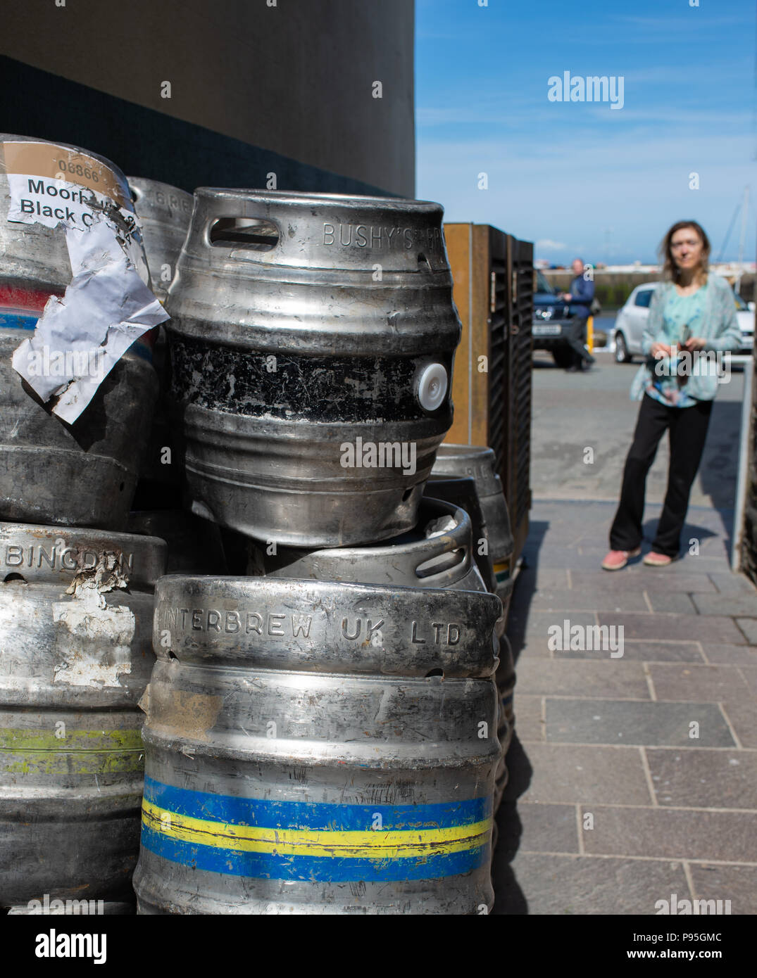 Metal catering barrels piled up on a side walk Stock Photo