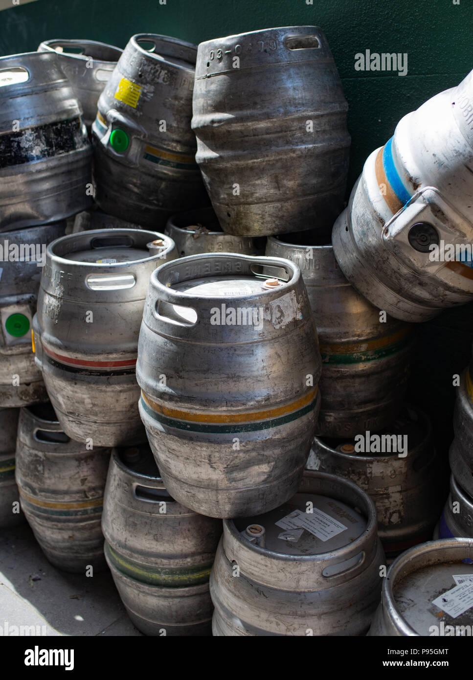 Metal catering barrels piled up on a side walk Stock Photo