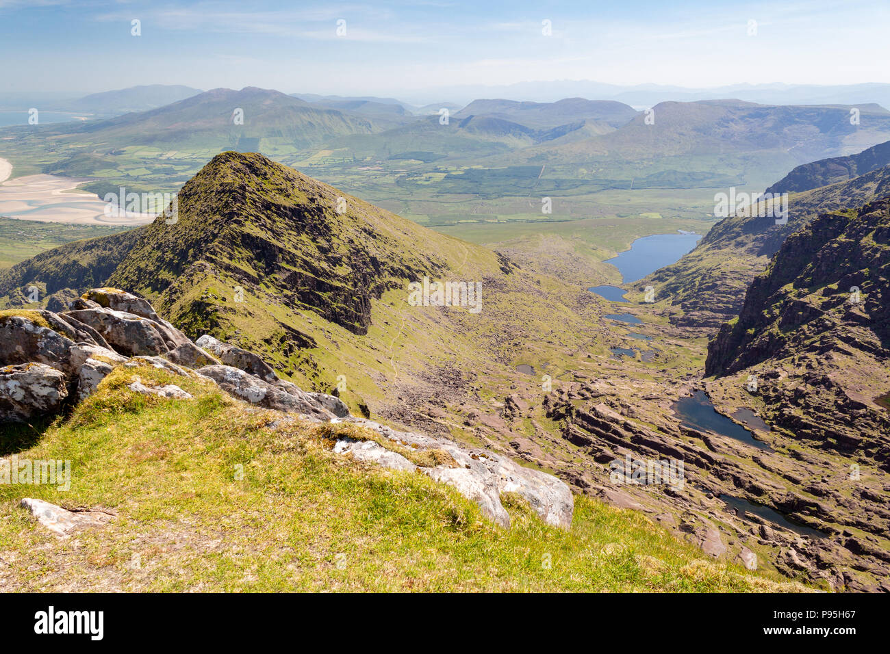 Summer view looking east along Faha Ridge and Pater Noster Lakes towards mountains of the Dingle Peninsula in County Kerry, Ireland Stock Photo