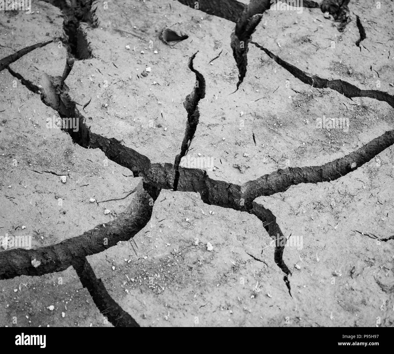 Dry cracked mud at the bottom of dried reservoir Stock Photo