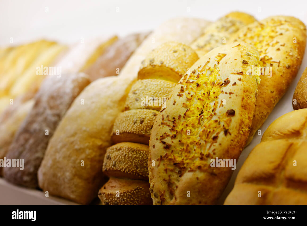 Different types of bread on a bakery display. Selective focus. Stock Photo
