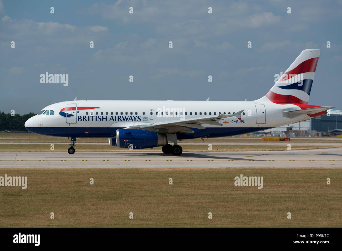 A British Airways A319 sits on the runway at Manchester Airport as it prepares to take-off. Stock Photo