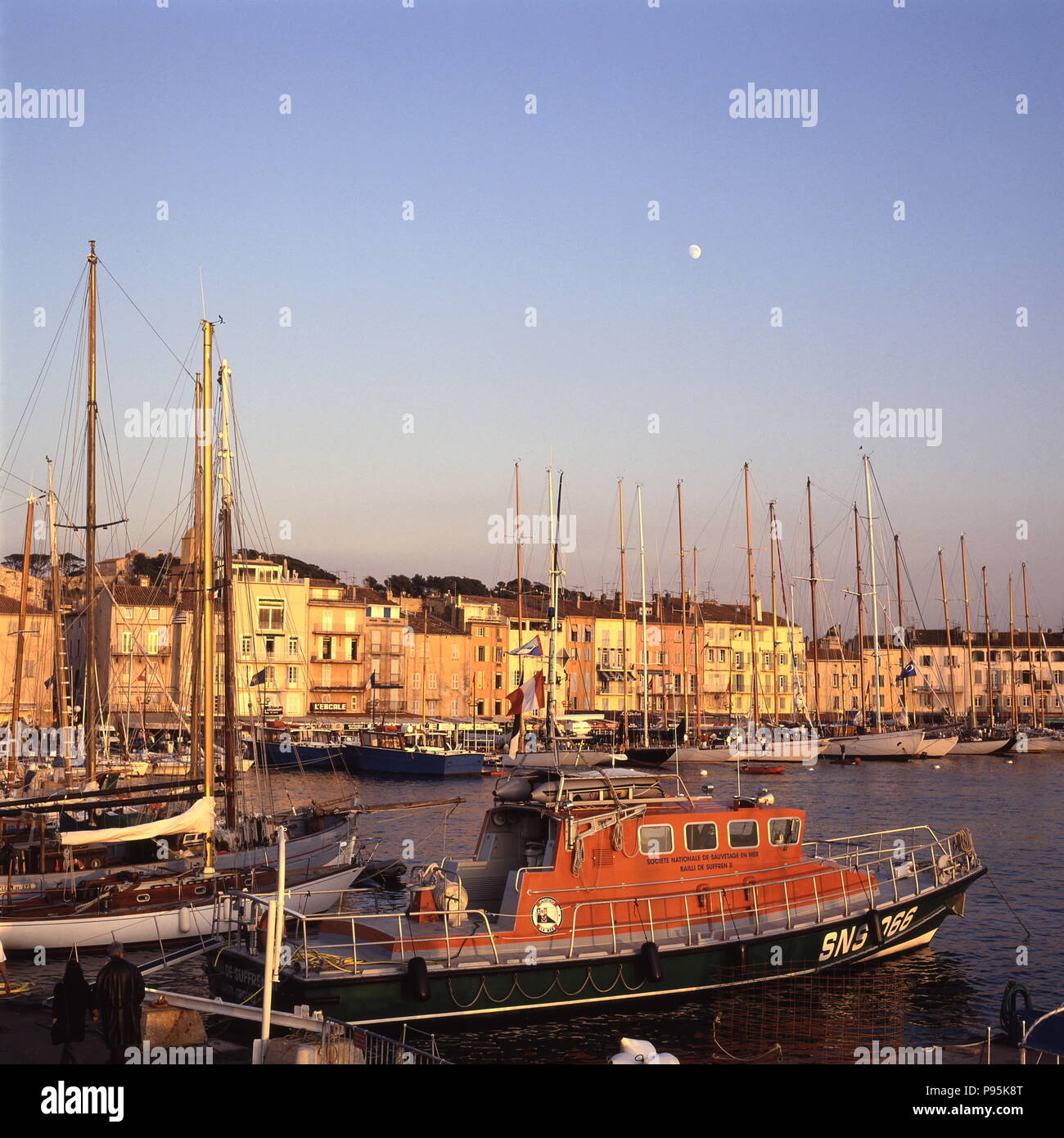 AJAXNETPHOTO. ST.TROPEZ, FRANCE. - PLAYGROUND OF THE RICH - MOON RISES OVER THE COTE D'AZUR HARBOUR ON THE MEDITERRANEAN. SOCIETE NATIONALE DE SAUVETAGE EN MER LIFEBOAT BAILLI DE SUFFREN II IS IN THE LEFT FOREGROUND. PHOTO:JONATHAN EASTLAND/AJAX REF:921904 15 Stock Photo