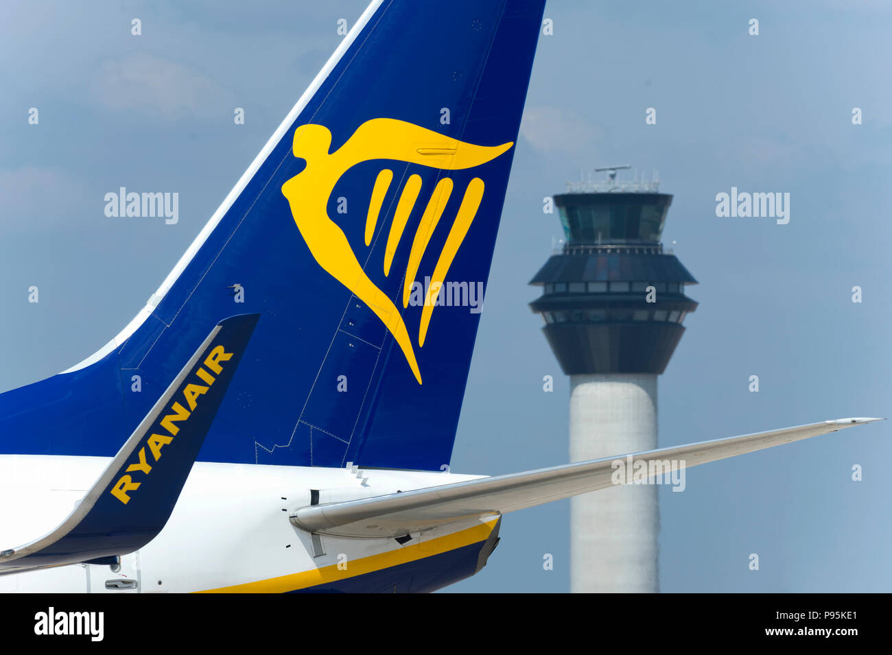The tailfin of Ryanair Boeing 737-800 taxiing along the runway in front of the control tower at Manchester Airport. Stock Photo