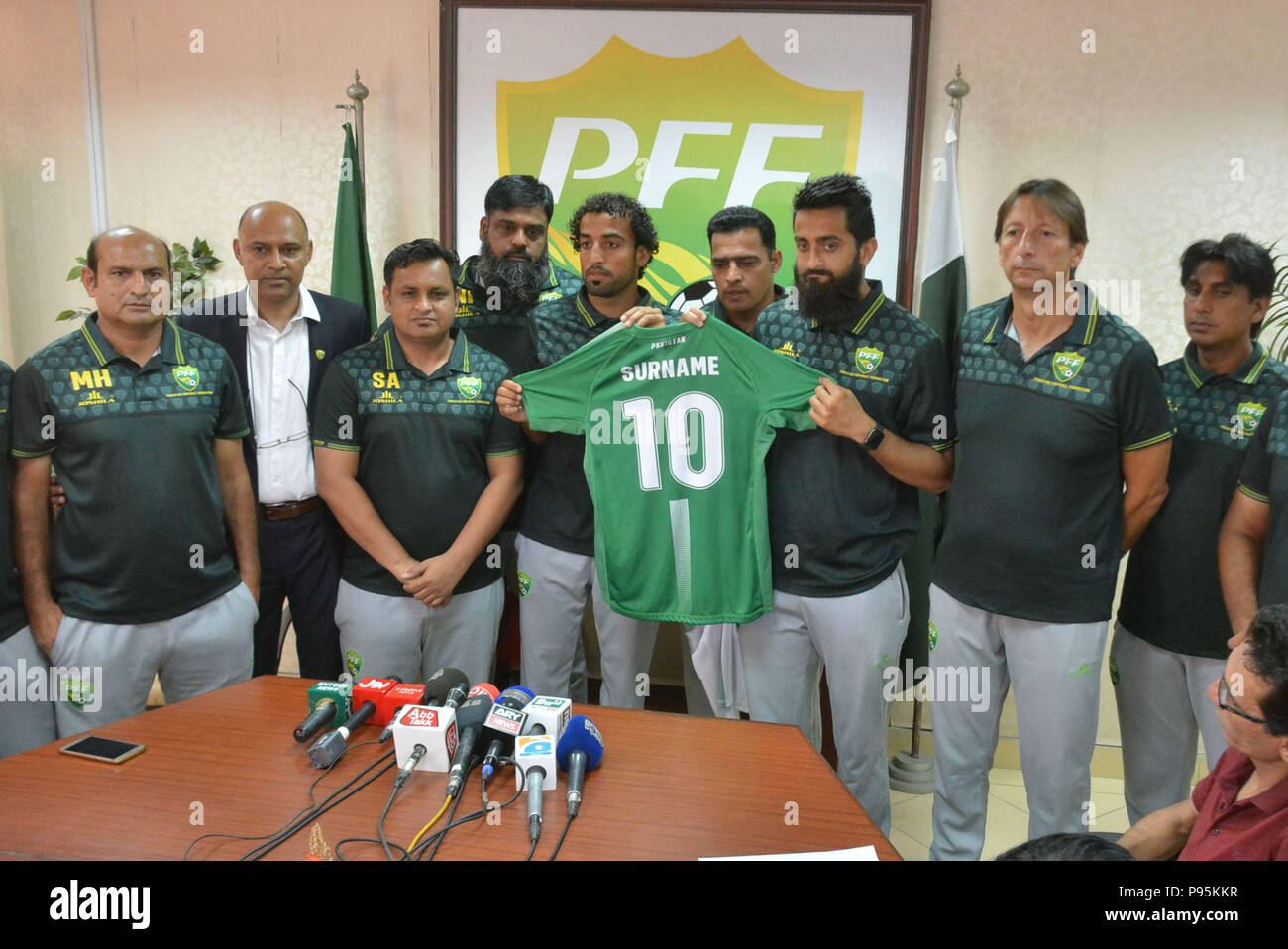 Lahore, Pakistan. 15th July, 2018. Pakistani officials, Brazilian head  coach Jose Antonio Nogueira, coach Shahid Anwar, Media Marketing manager  Shahid Khokhar and players of national football team unveiling the kits of  upcoming