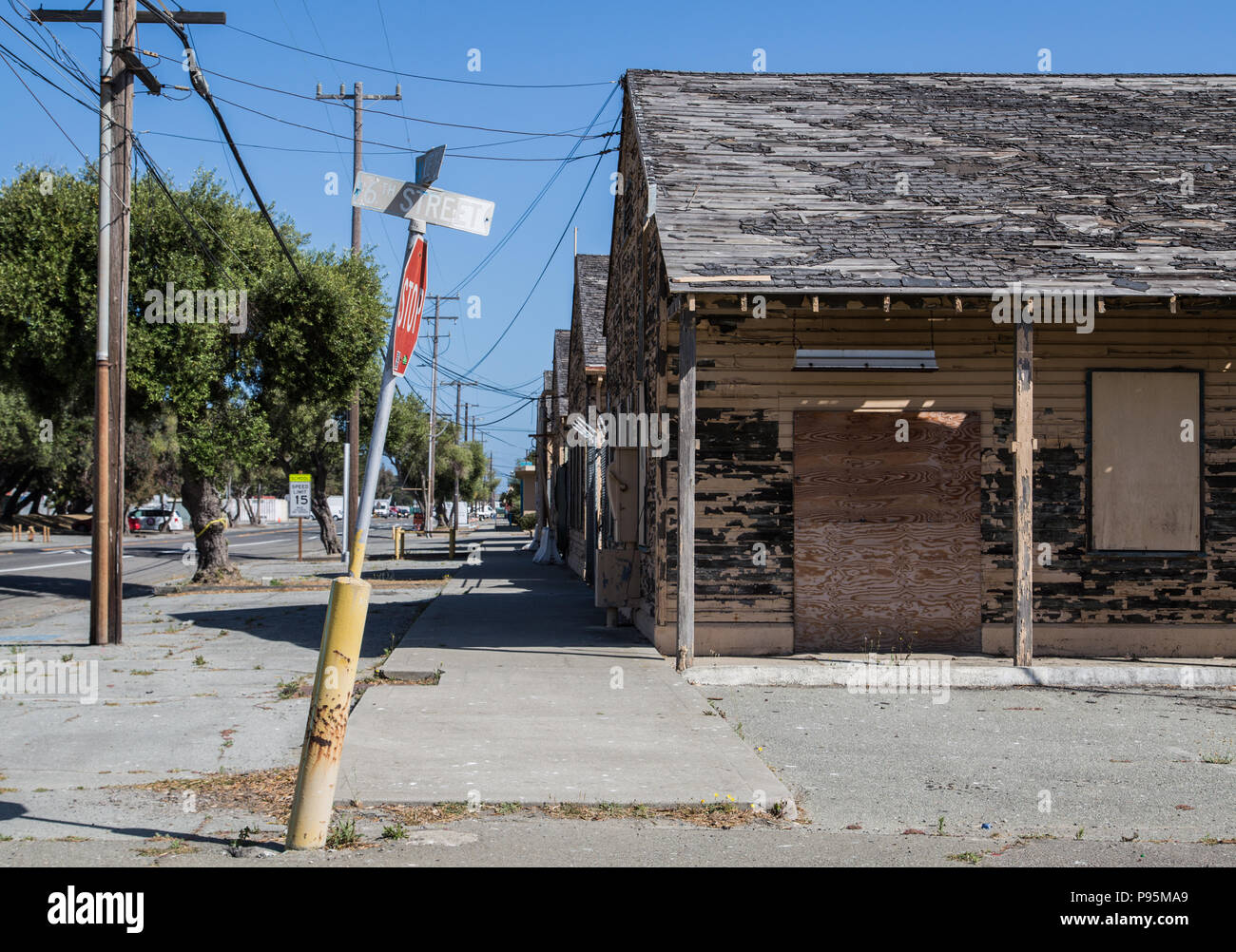 An old, bent stop sign in front of an abandoned military building on