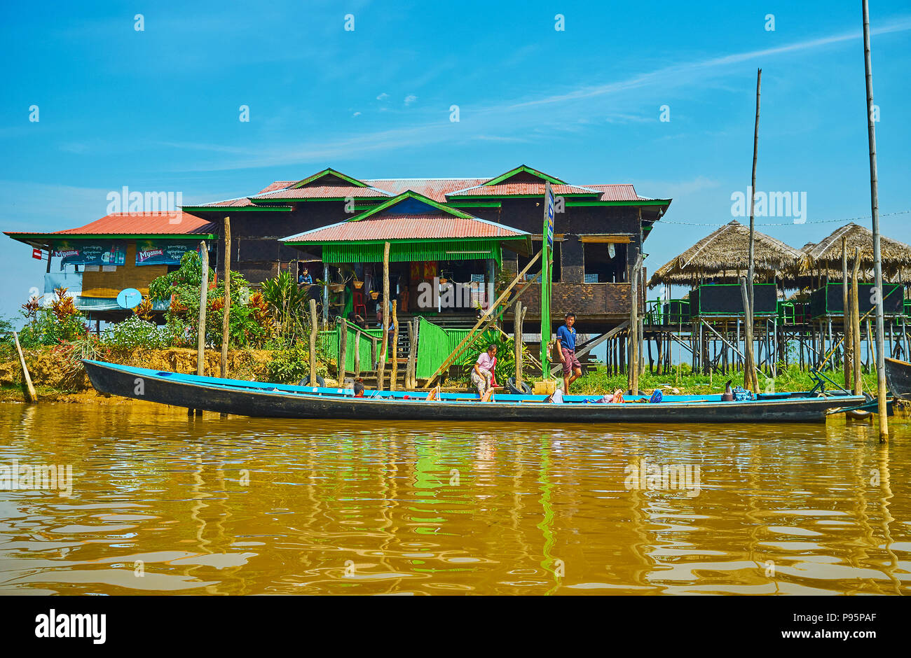 YWAMA, MYANMAR - FEBRUARY 18, 2018: The colorful wooden house on stilts with small pavilions serves as the tourist cafe on Inle Lake, on February 18 i Stock Photo