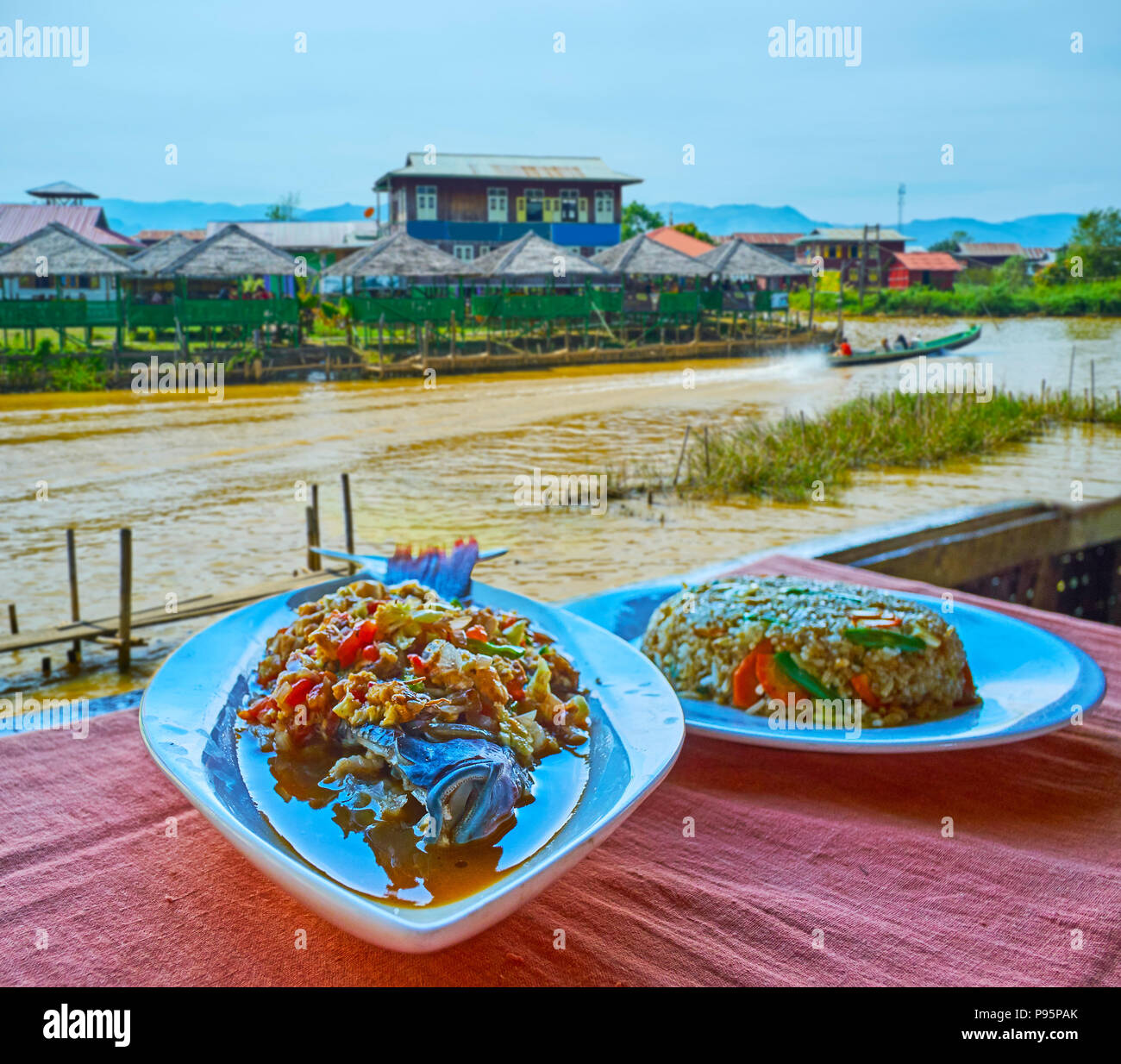 The tasty dishes of Burmese cuisine in restaurant on Inle Lake - the spicy rice and fish with vegetables are the most popular dinner on the lake, Ywam Stock Photo