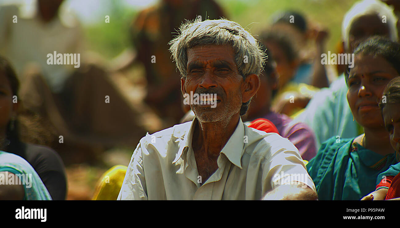 Portrait of a smiling farmer sitting on field, nature background Stock ...