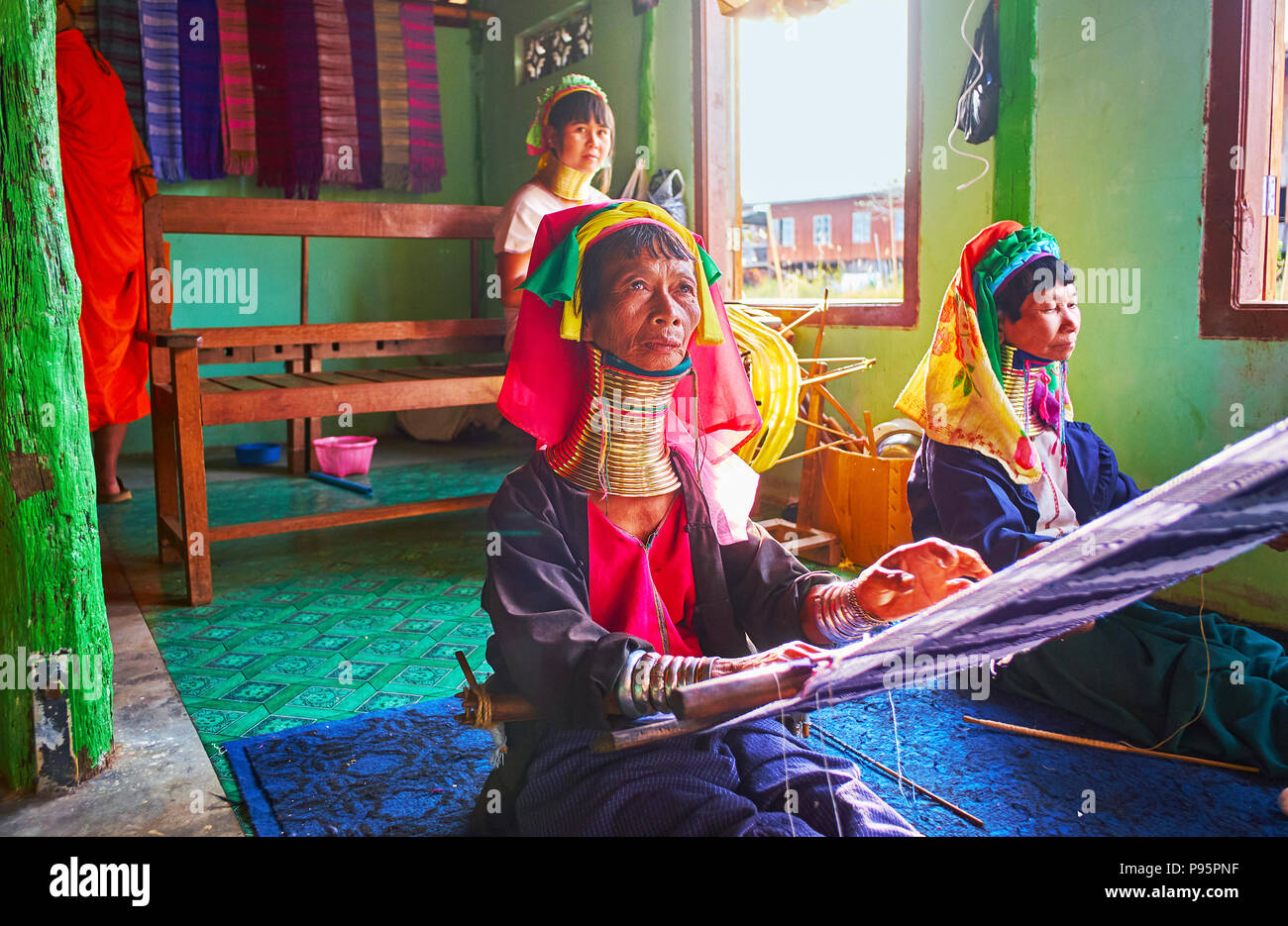 INLE LAKE, MYANMAR - FEBRUARY 18, 2018: The long neck women of Padaung Kayan tribe attract the tourists to visit their traditional textile workshop a Stock Photo